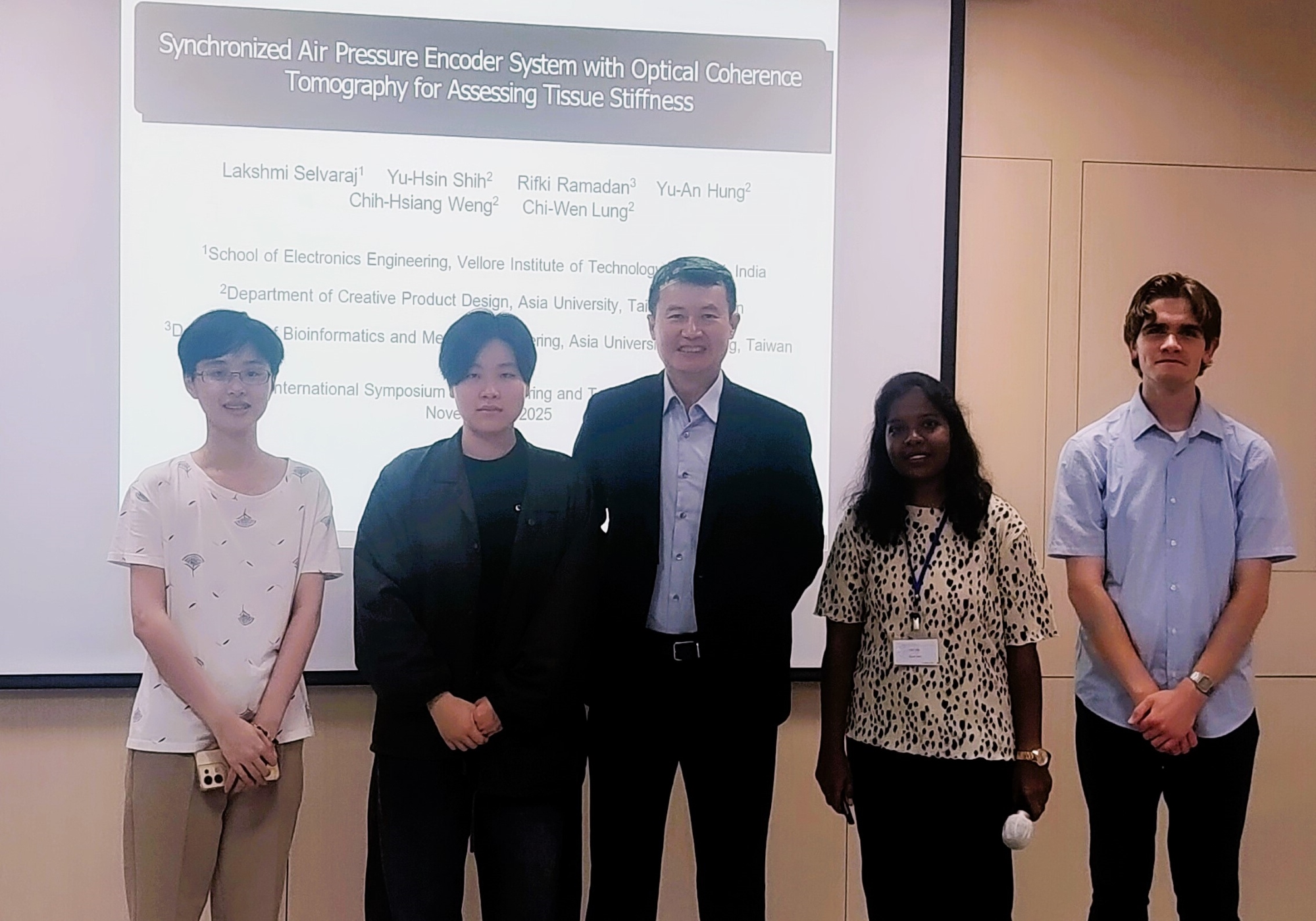ISET 2025 國際研討會場亞大商品系師生合影。IIPP實習美國大學生 Brady Mitchell Perkins (右起)、TEEP實習印度博士生 Lakshmi Selvaraj、商設系龍希文老師、商品碩士生洪禹安、施語忻。