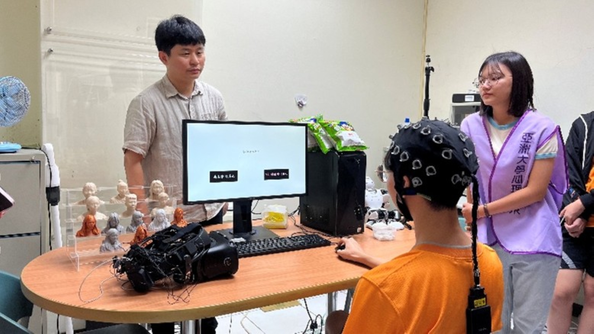 葉品陽老師（左）的神經心理學腦波EEG實驗結合語言模型分析風險決策行為。