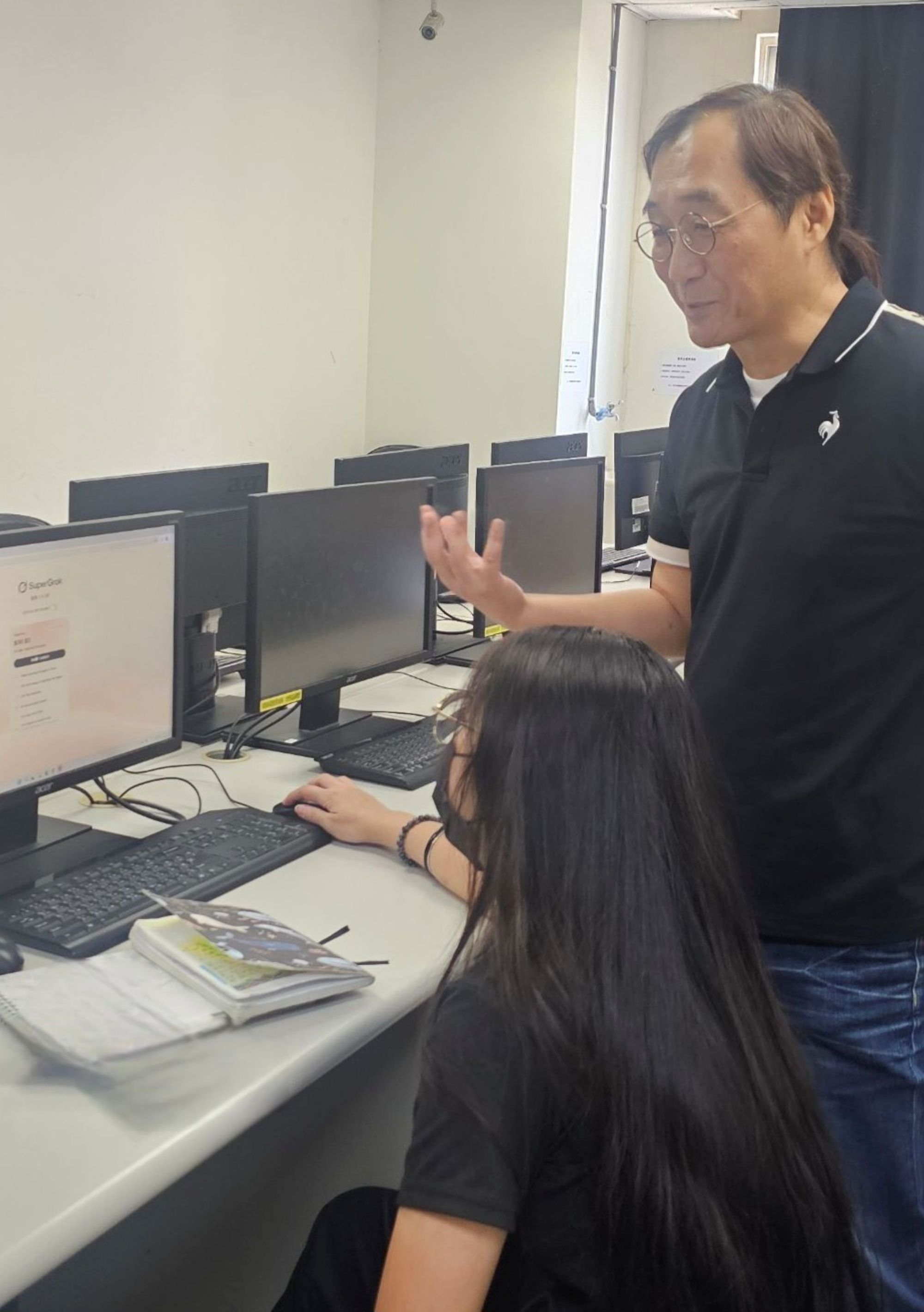 資深原畫師王瑋名(右)於實作課程中,親身指導學生操作AI工具進行音樂創作演練。