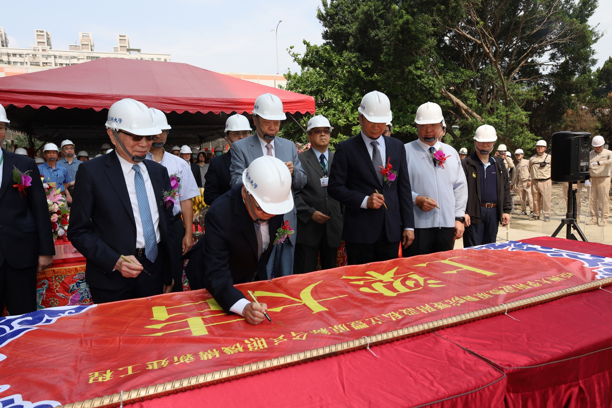 亞大創辦人、校長等長官與貴賓共同於主樑紅布條上簽名,為豐原院區注入祝福並見證立基。