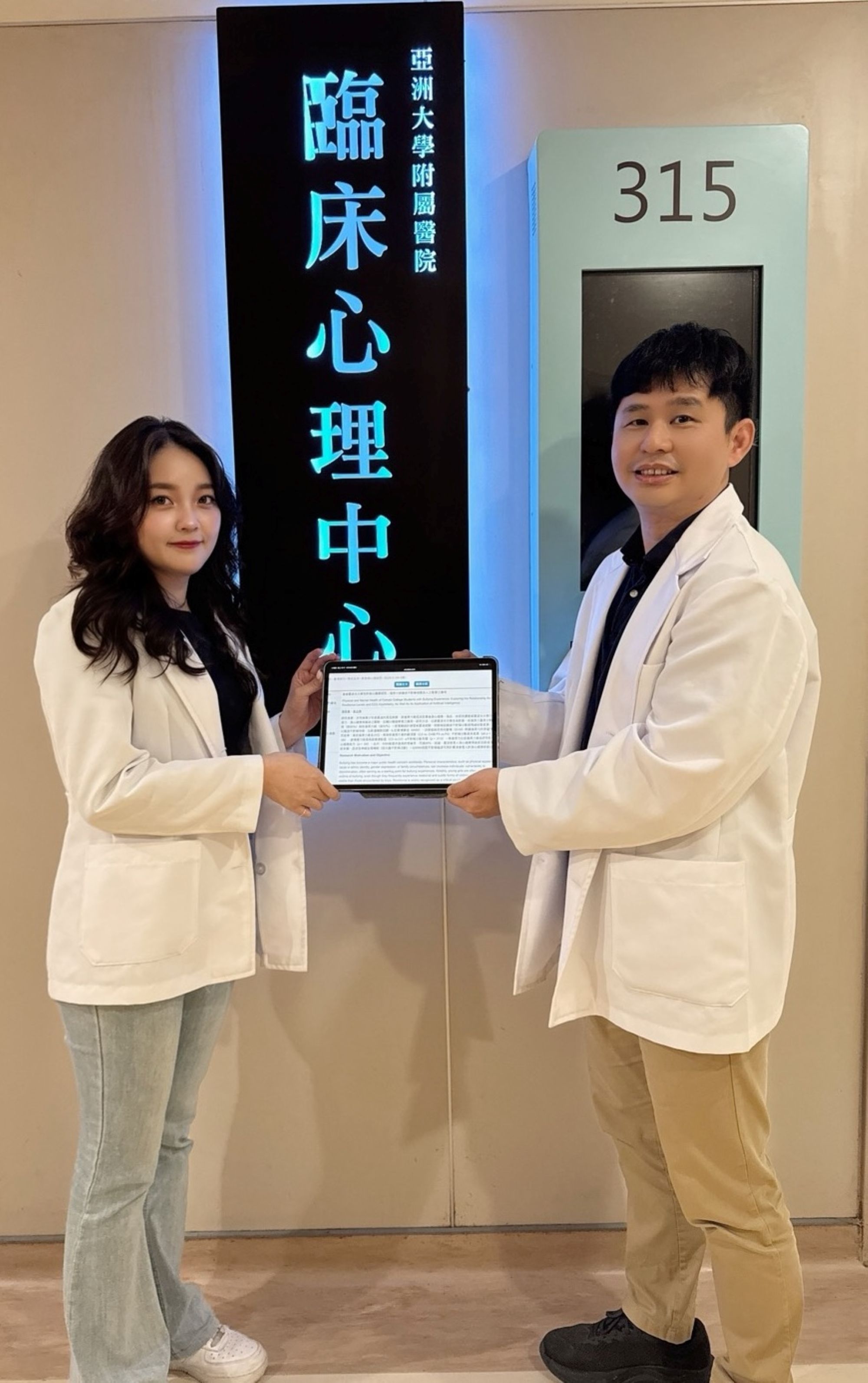 陳彥蓁（左）與葉品陽老師（右）合照，共同展示獲國家發明專利的「AI 心理辨識系統」。
