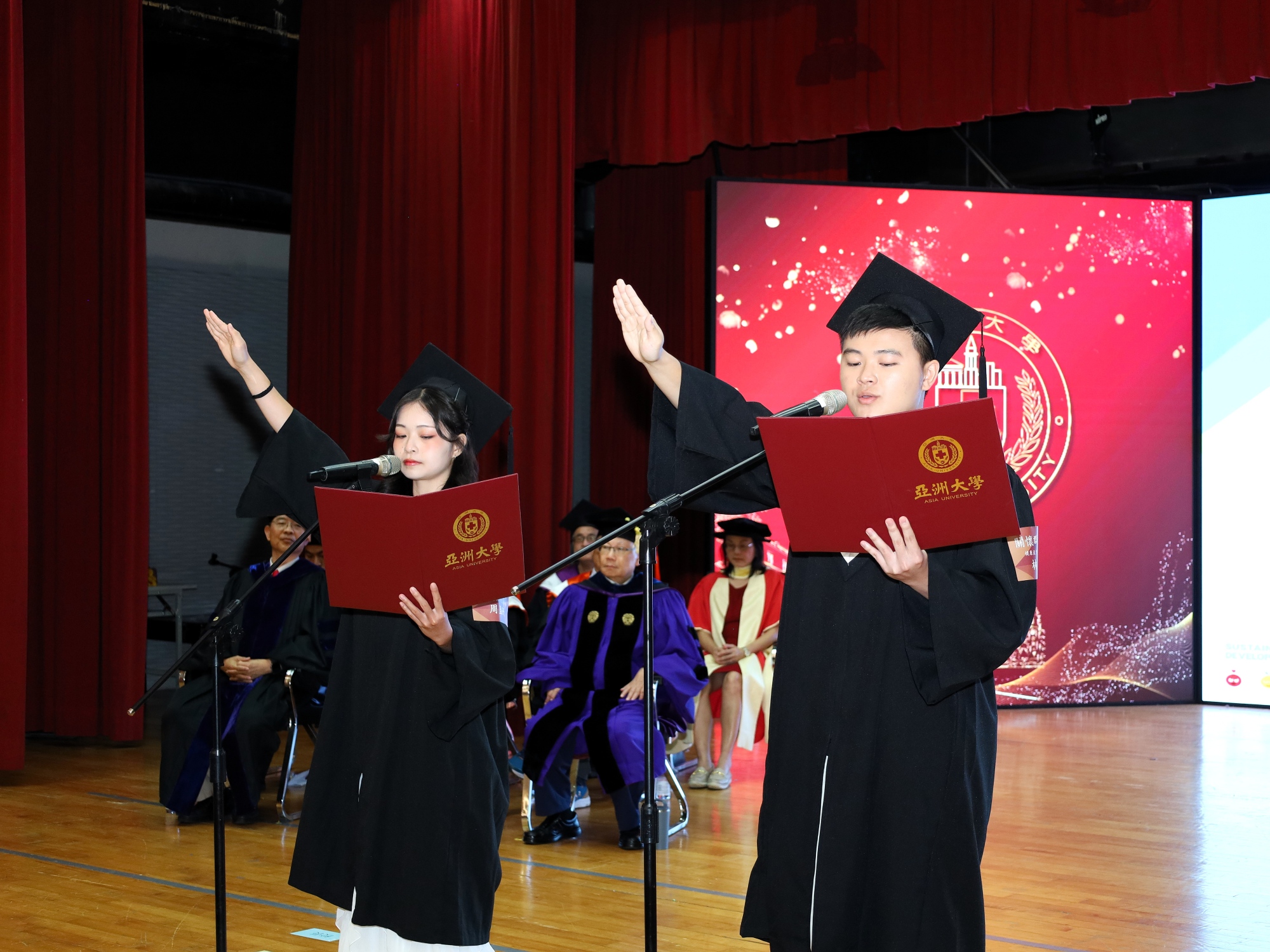 畢業生代表林恭介與周盈妤引領全體起立，莊嚴宣讀永續宣言，宣告亞大青年的實踐決心。