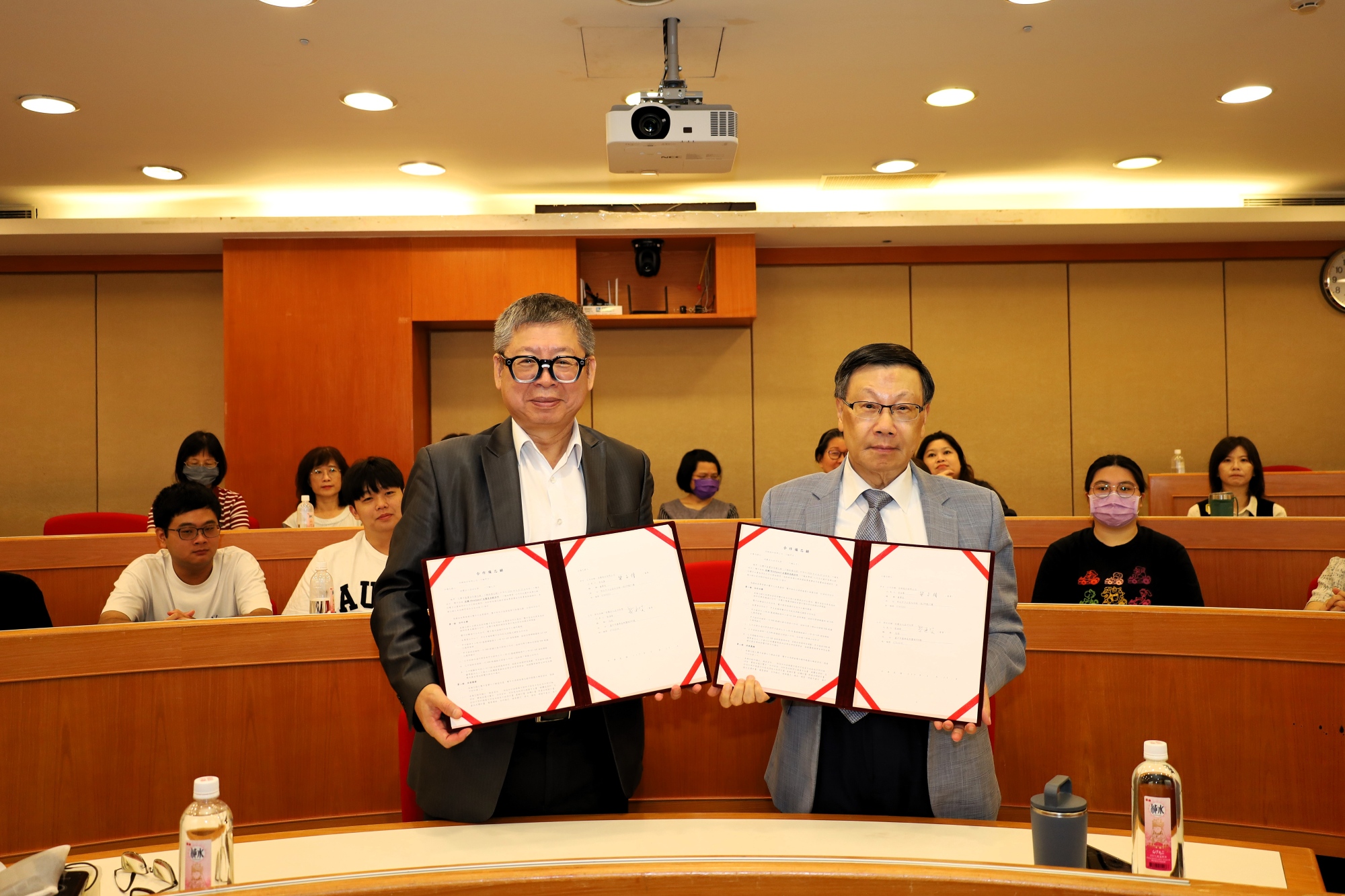 佐臻董事長梁文隆(左)與亞大校長蔡進發(右)共同展示產學合作備忘錄。