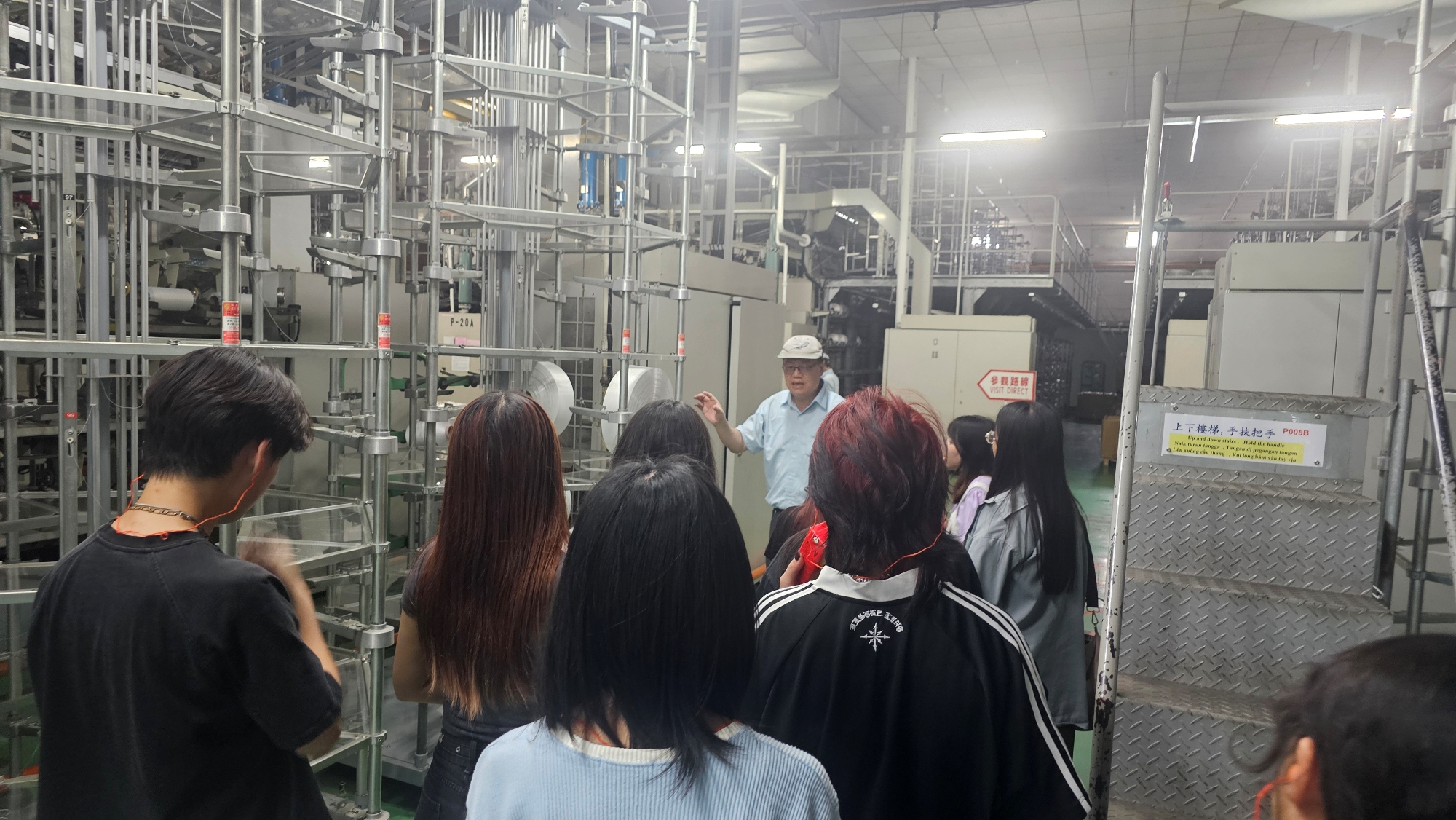 力鵬企業主管們為時尚系學生介紹廠內機台運用。