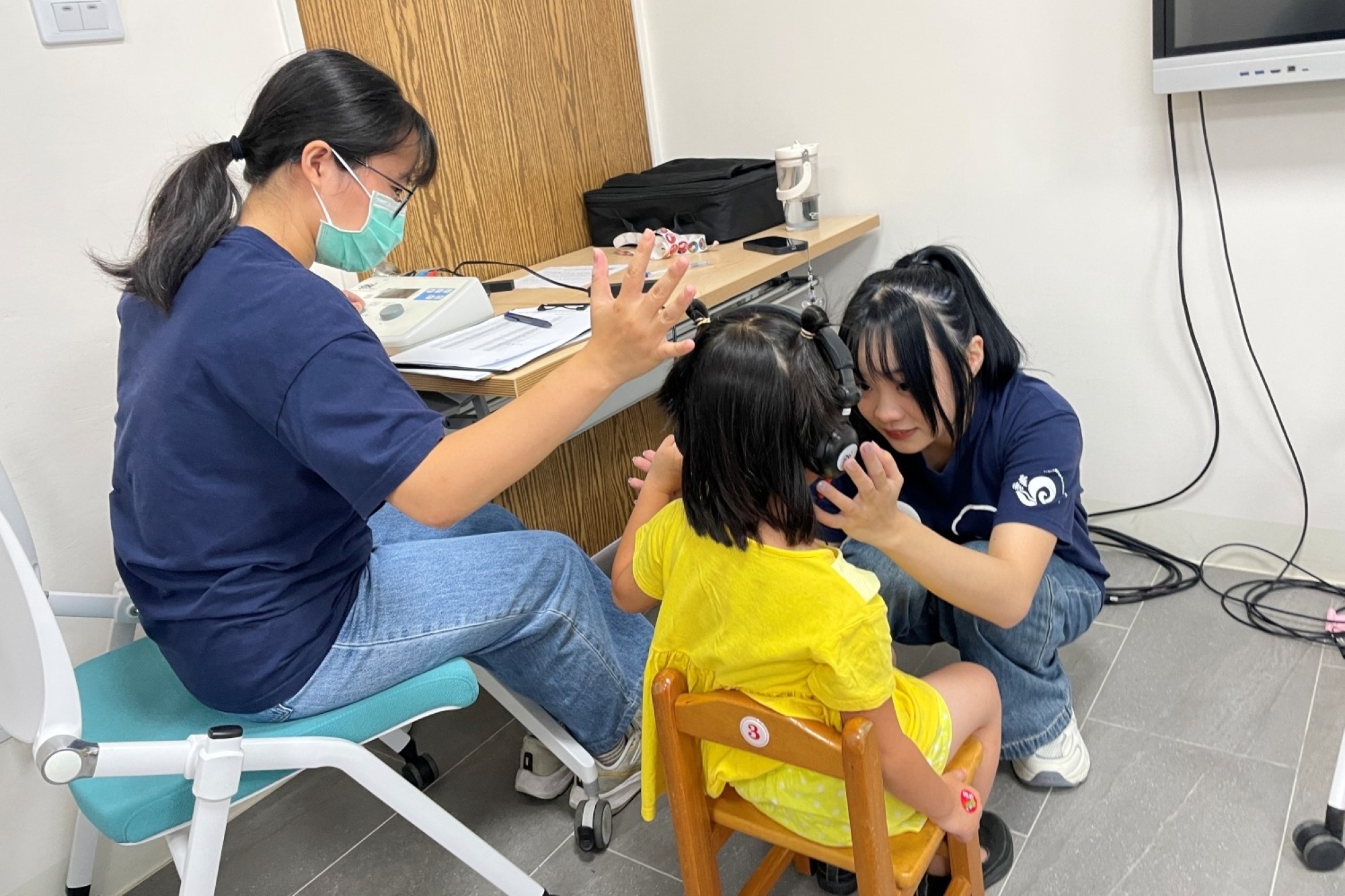 亞大聽語系學生透過互動方式,引導兒童體驗聽力檢查。