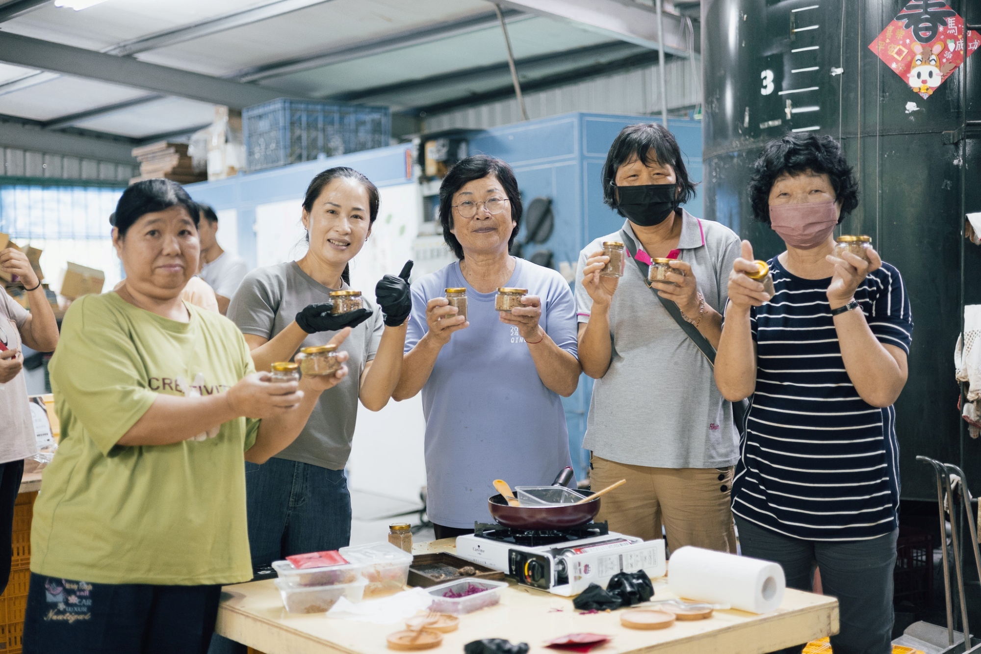 參加手作香菇堅果醬活動的民眾歡喜拿起完成品, 豎起大拇指稱讚意想不到的好吃味道