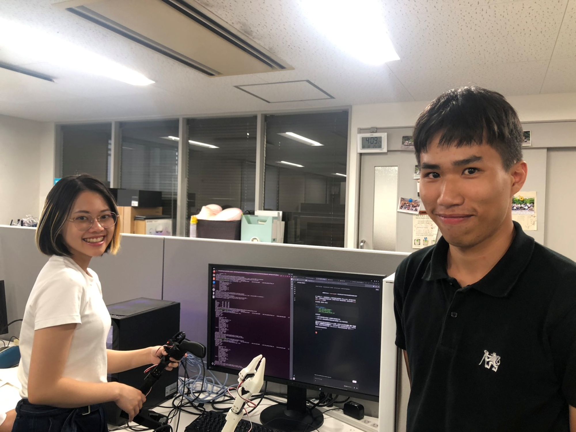 計畫團隊成員於大阪大學研究室操作機械手臂與 AI 程式進行實作測試。