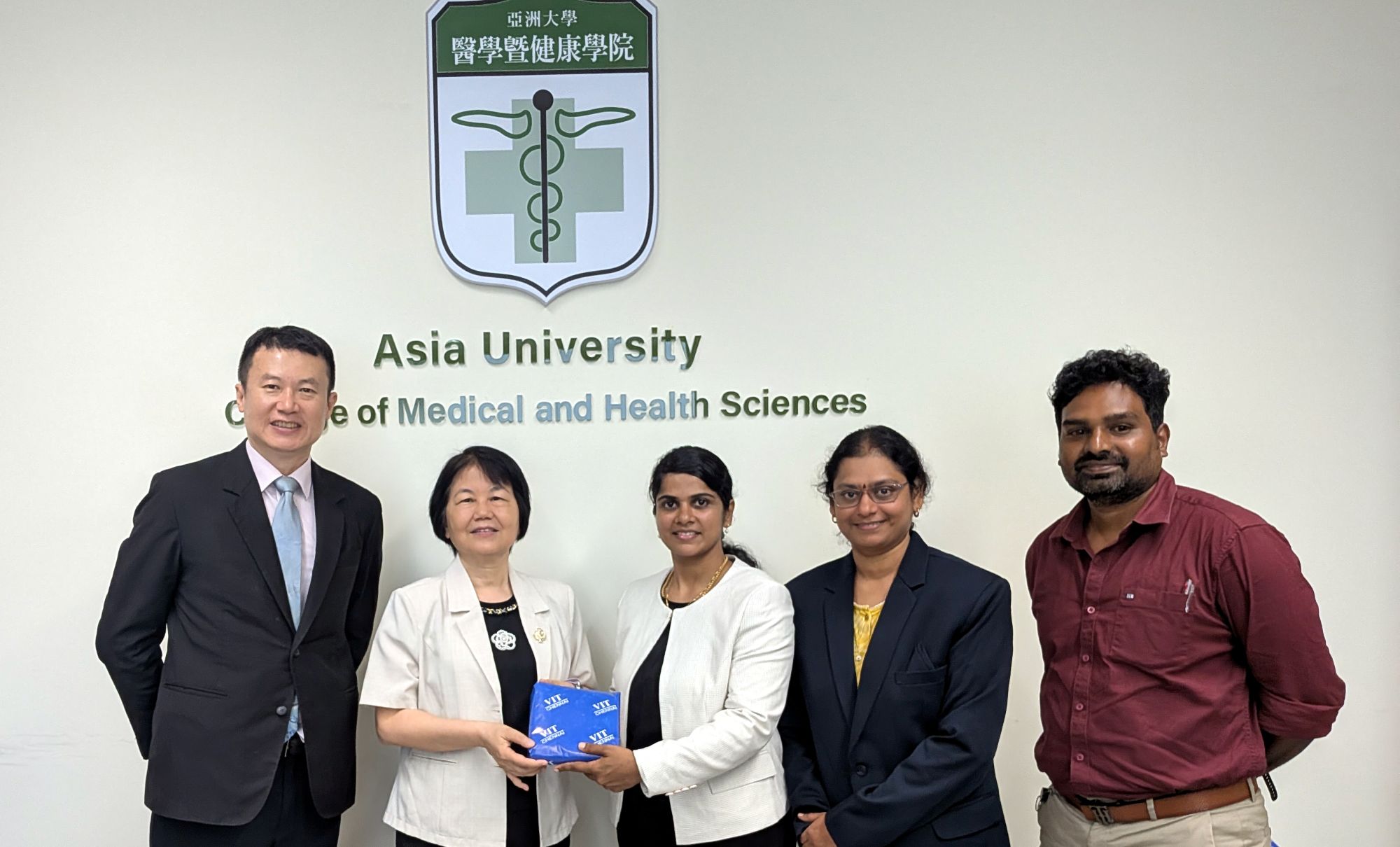 亞洲大學醫學暨健康學院院長胡淑貞教授(左2)與印度韋洛爾理工大學清奈校區 Dr. Sheen Christabel Pravin(左3)、Dr. Kiruthika Venkataramani(右2)、Dr. Abraham Sudharson Ponraj(右1)互贈紀念品,雙方聚焦醫療量子AI應用、AI醫學影像判讀與臨床驗證等合作議題。