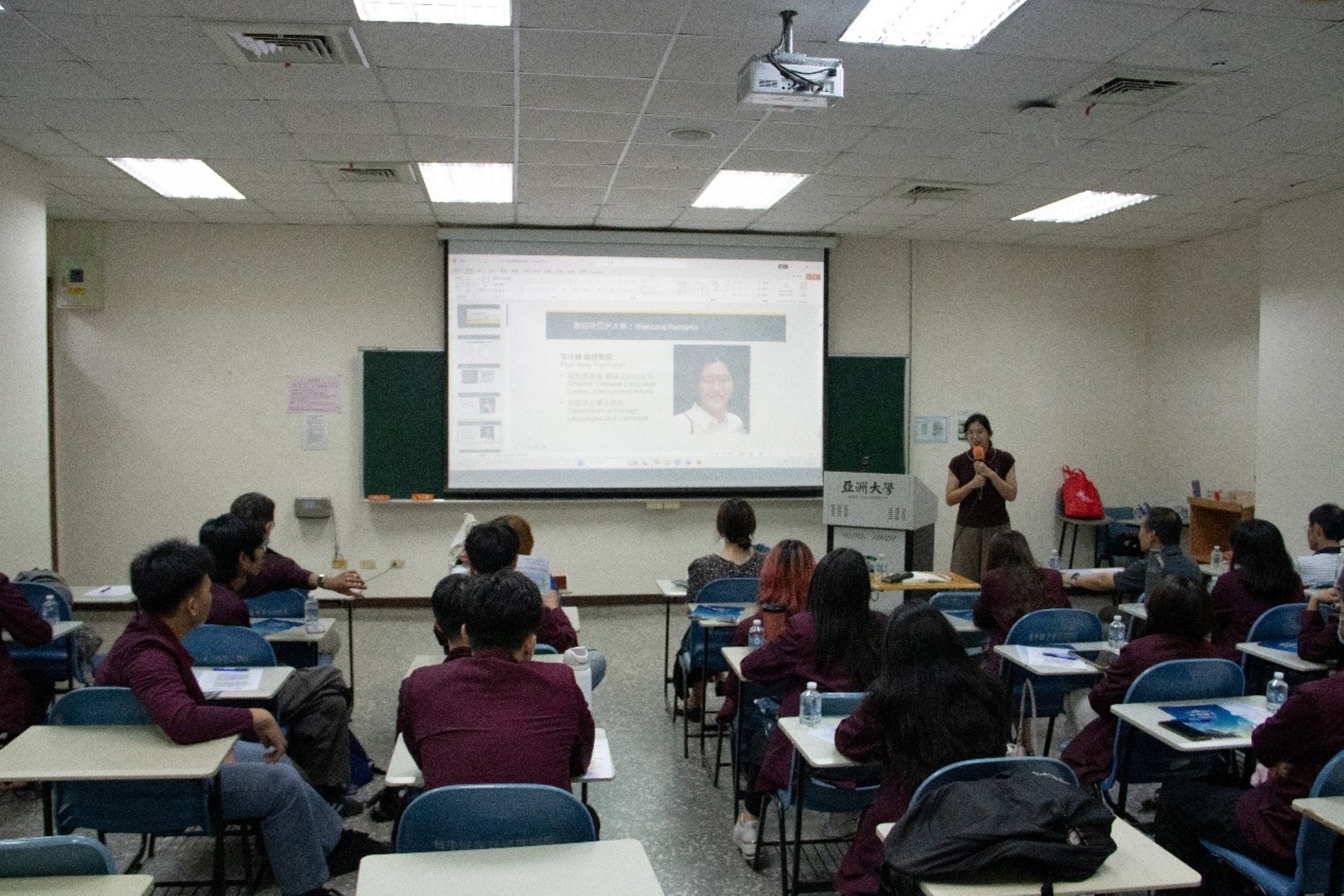 Director Mao, Yuen-Jean of the Chinese Language Center reviews last year's video on stage with the students, leaving them eagerly anticipating the upcoming activities