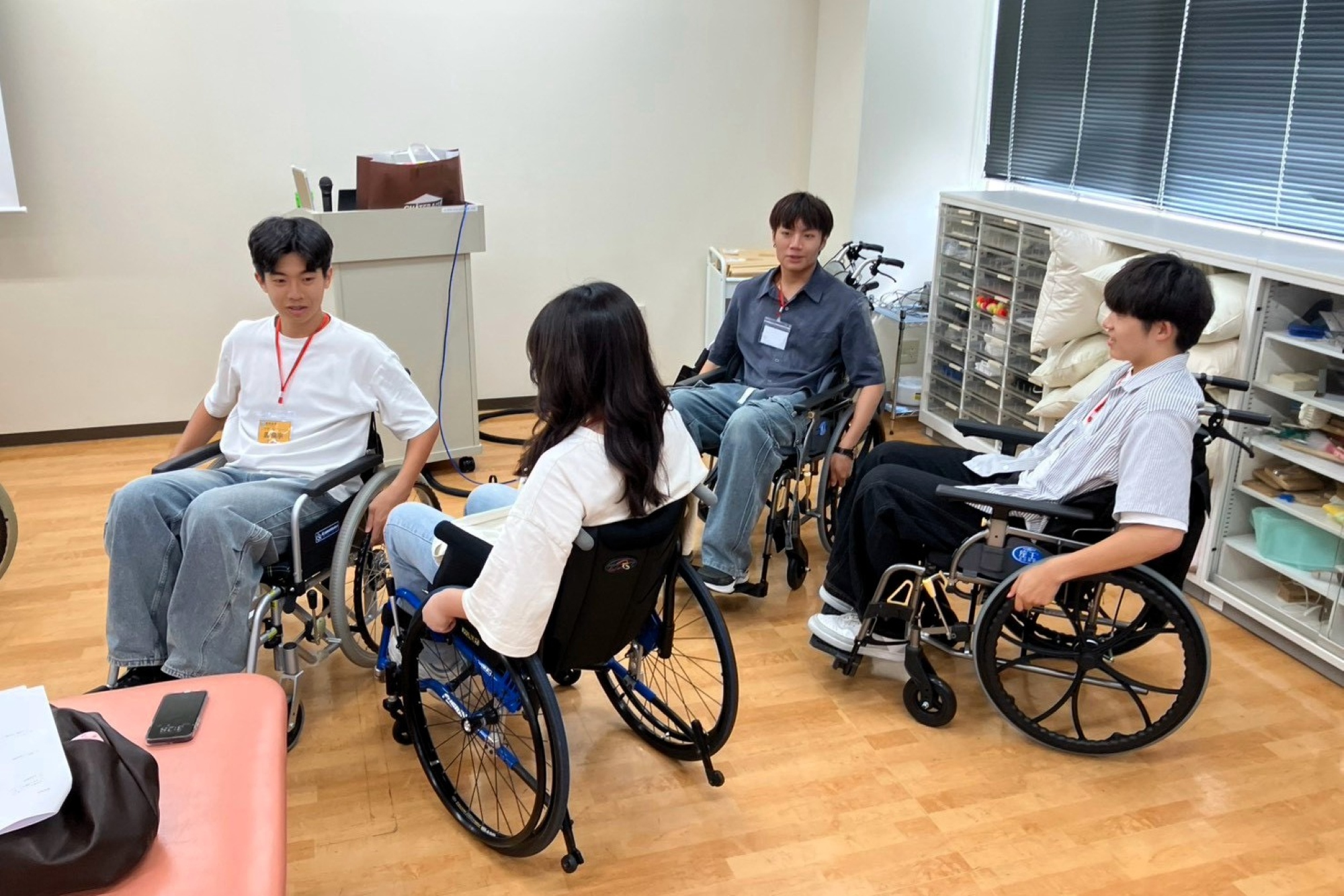 學生於照護前親身體驗並練習輪椅操作，從同理心出發學習照護細節。