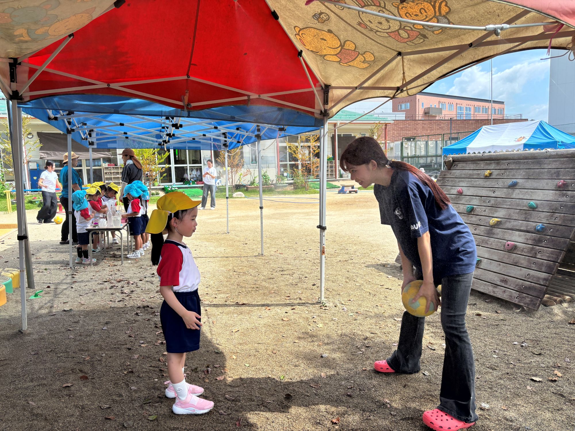 實習生曾詩涵於戶外引導日本幼兒晨間活動，透過互動激發自主學習。