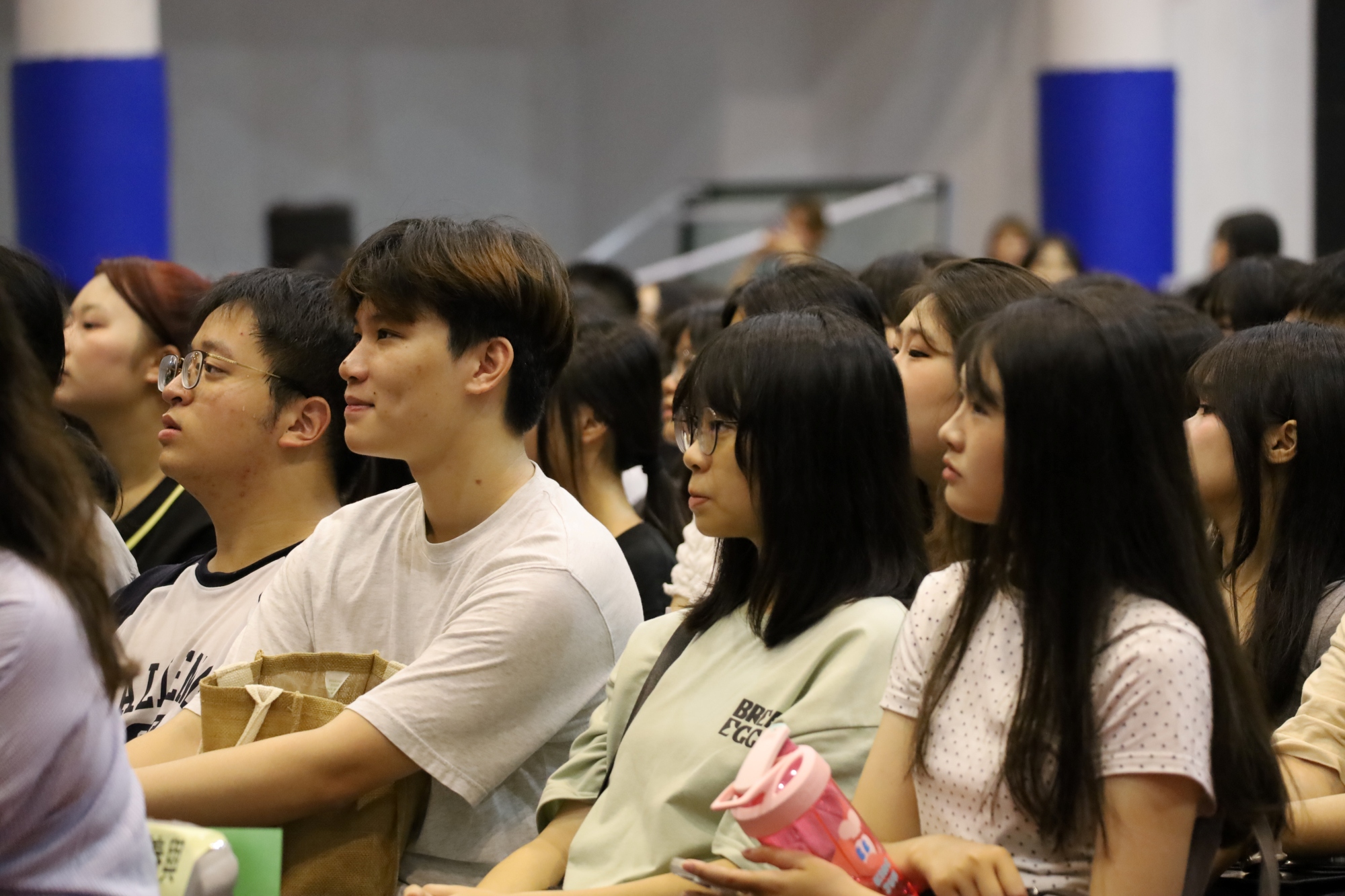現場新生專注聆聽師長致詞與分享,眼神充滿對大學的期待。
